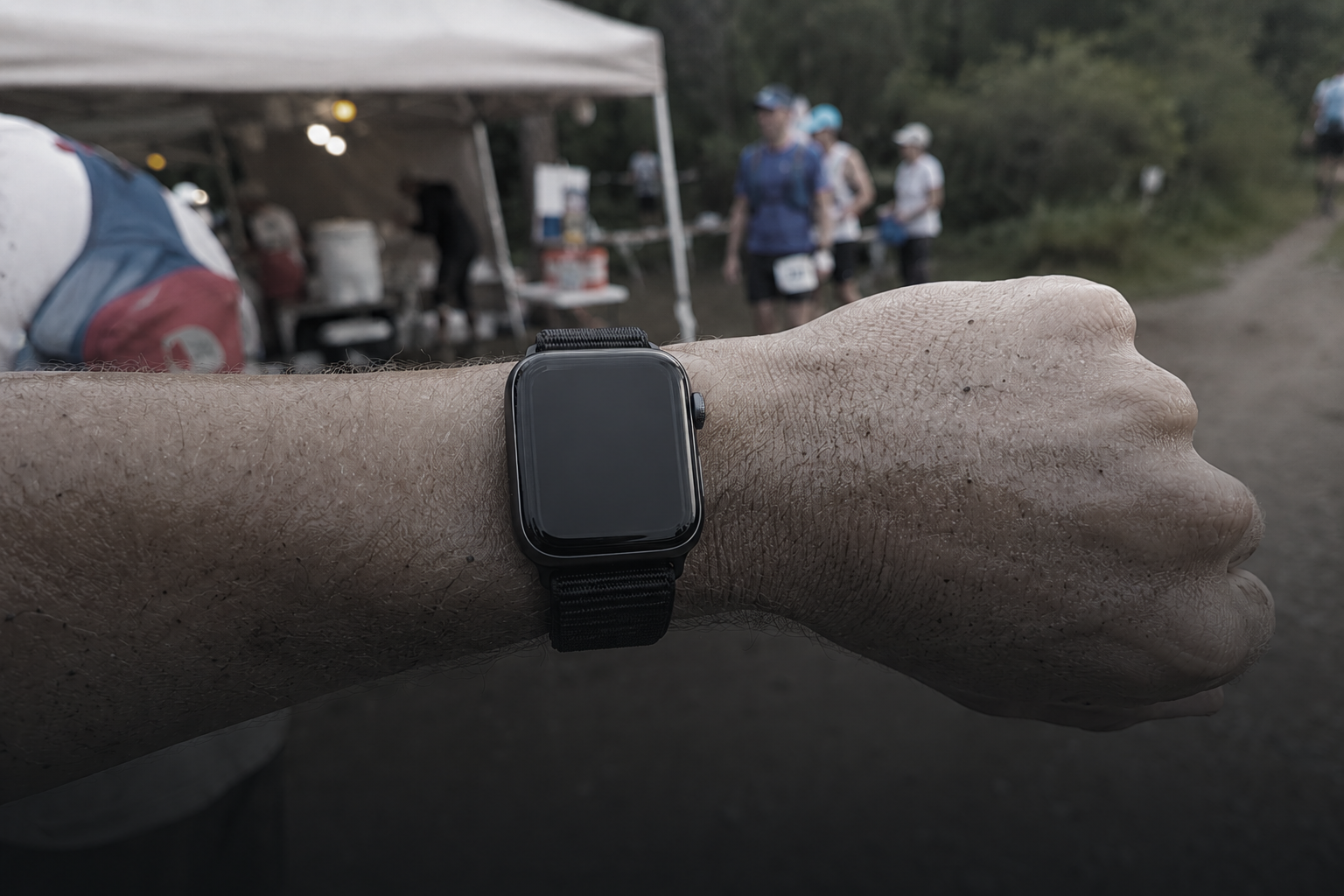 Runner glancing at Apple Watch during a Backyard Ultra lap